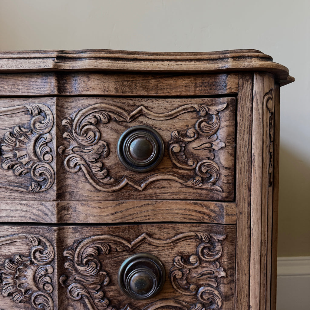 Wooden cabinet with intricate carvings and two knobs
